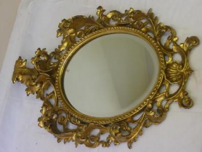 Appraisal: A FLORENTINE GILT WOOD WALL MIRROR the oval bevelled plate