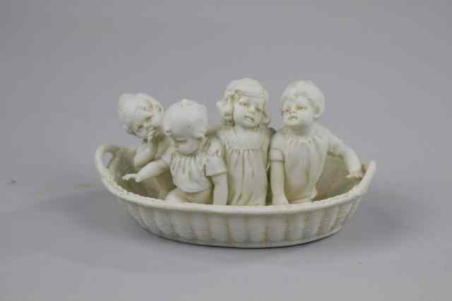 Appraisal: HERTWIG PARIAN CHILDREN IN BASKET FIGURINE Charming all white bisque