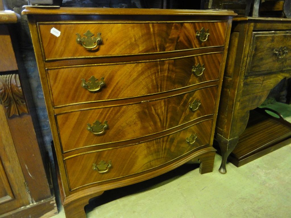 Appraisal: A reproduction mahogany serpentine chest in the Georgian style fitted