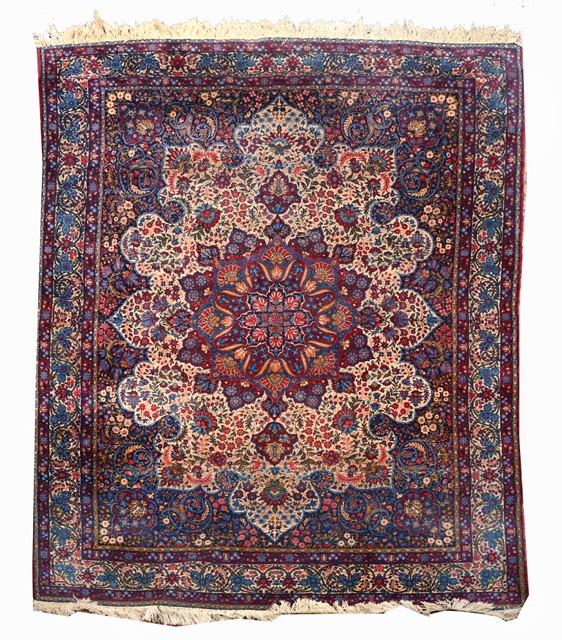 Appraisal: A KIRMAN BLUE GROUND CARPET the large central foliate medallion