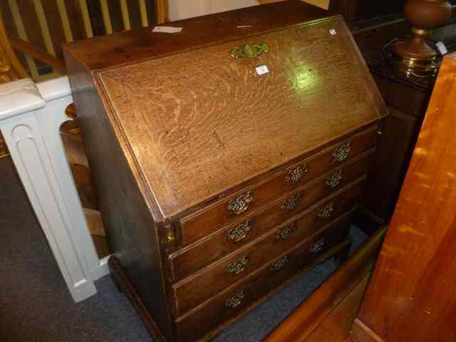 Appraisal: A GEORGIAN OAK BUREAU fitted with four long graduated drawers