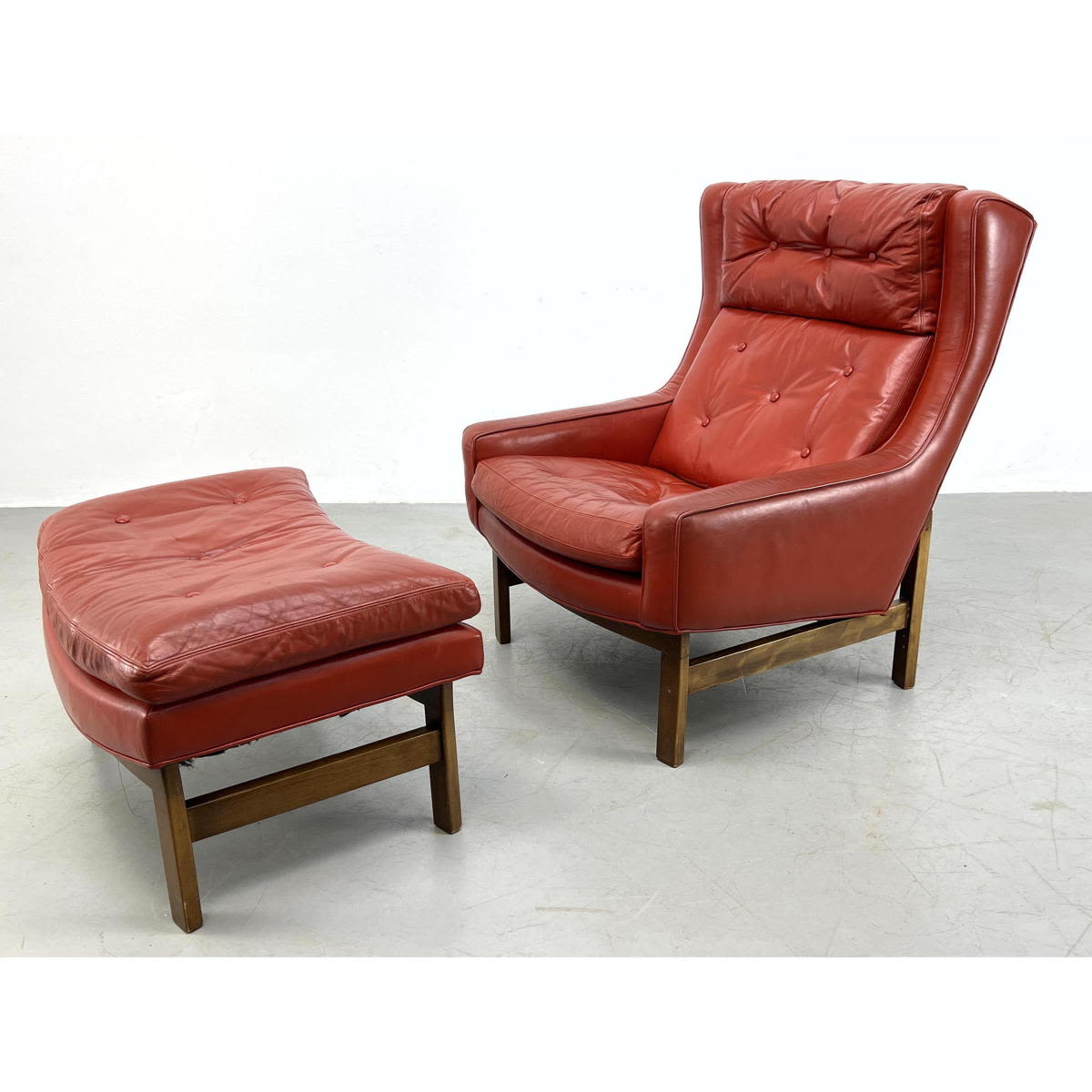 Appraisal: Red Leather Dunbar style lounge chair and ottoman Exposed frame