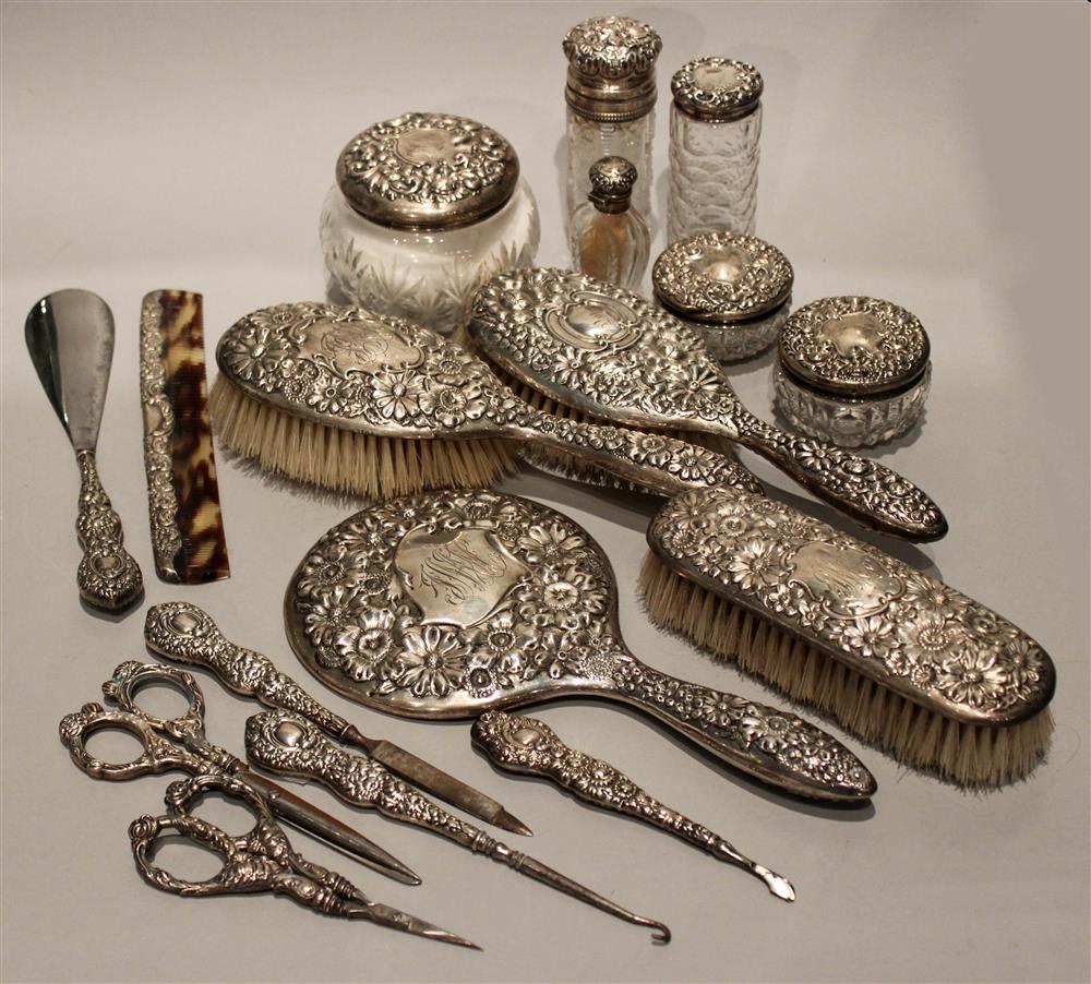 Appraisal: AN ASSEMBLED FLORAL REPOUSSE SILVER-BACKED DRESSER SET with central cartouches