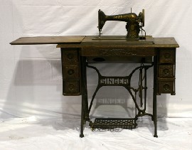 Appraisal: An oak veneer and cast iron Singer sewing machine table