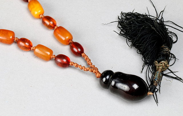 Appraisal: A CHINESE AMBER BEAD NECKLACE with clear and solid coloured