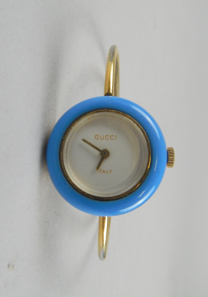 Appraisal: A Gucci ladies wristwatch with gold plated strap white dial