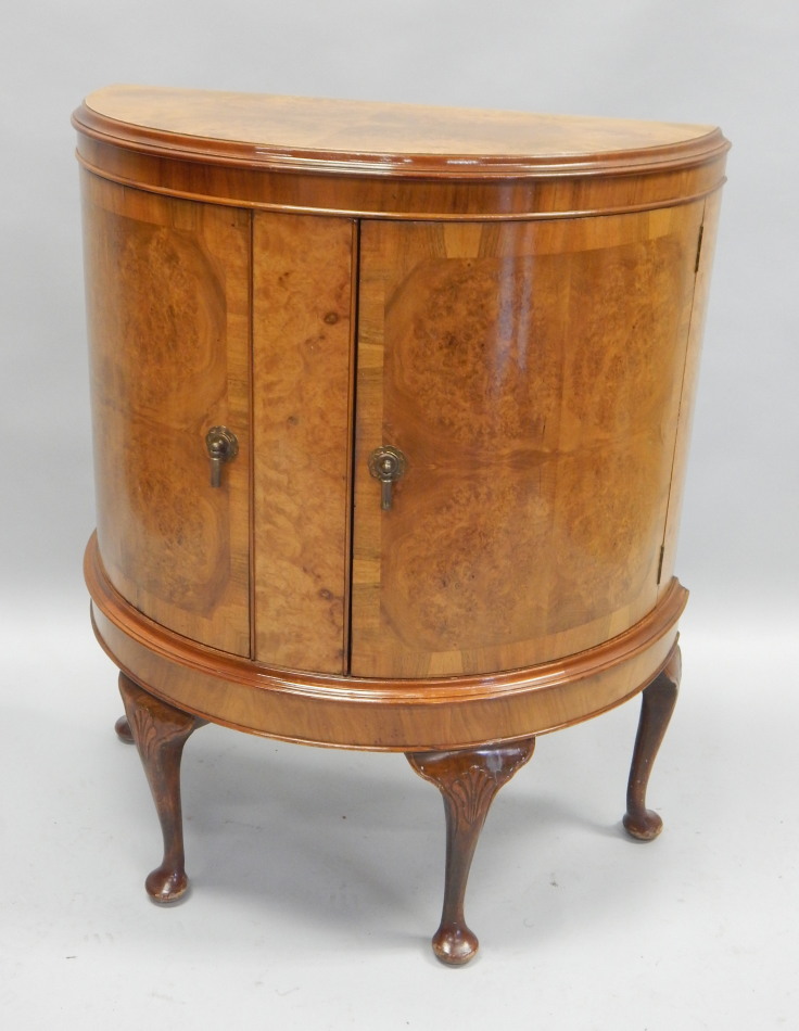 Appraisal: A reproduction burr walnut demi-lune side cabinet the top with