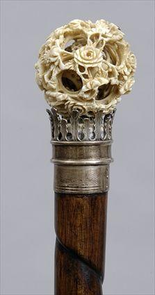 Appraisal: CHINESE IVORY PUZZLE BALL-HANDLED STAINED WOOD WALKING STICK The flower-carved