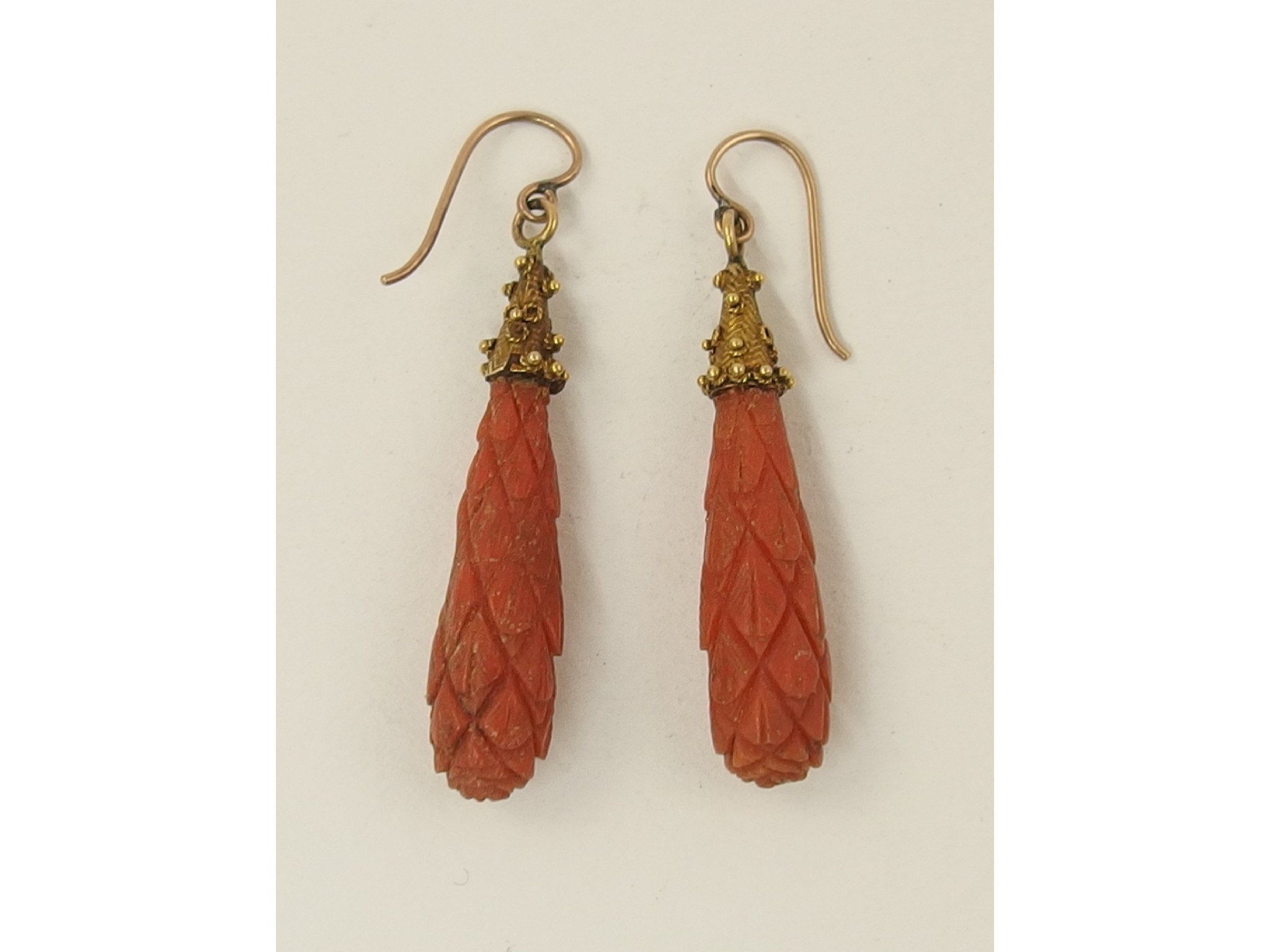 Appraisal: A pair of carved coral drop earrings with yellow metal