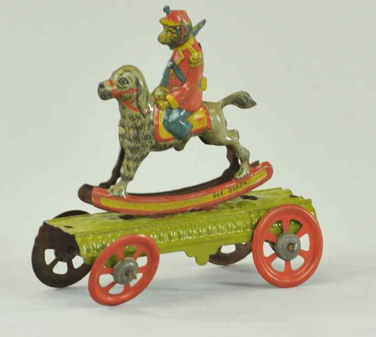 Appraisal: MONKEY ON ROCKING DOG PENNY TOY Embossed lithographed tin a