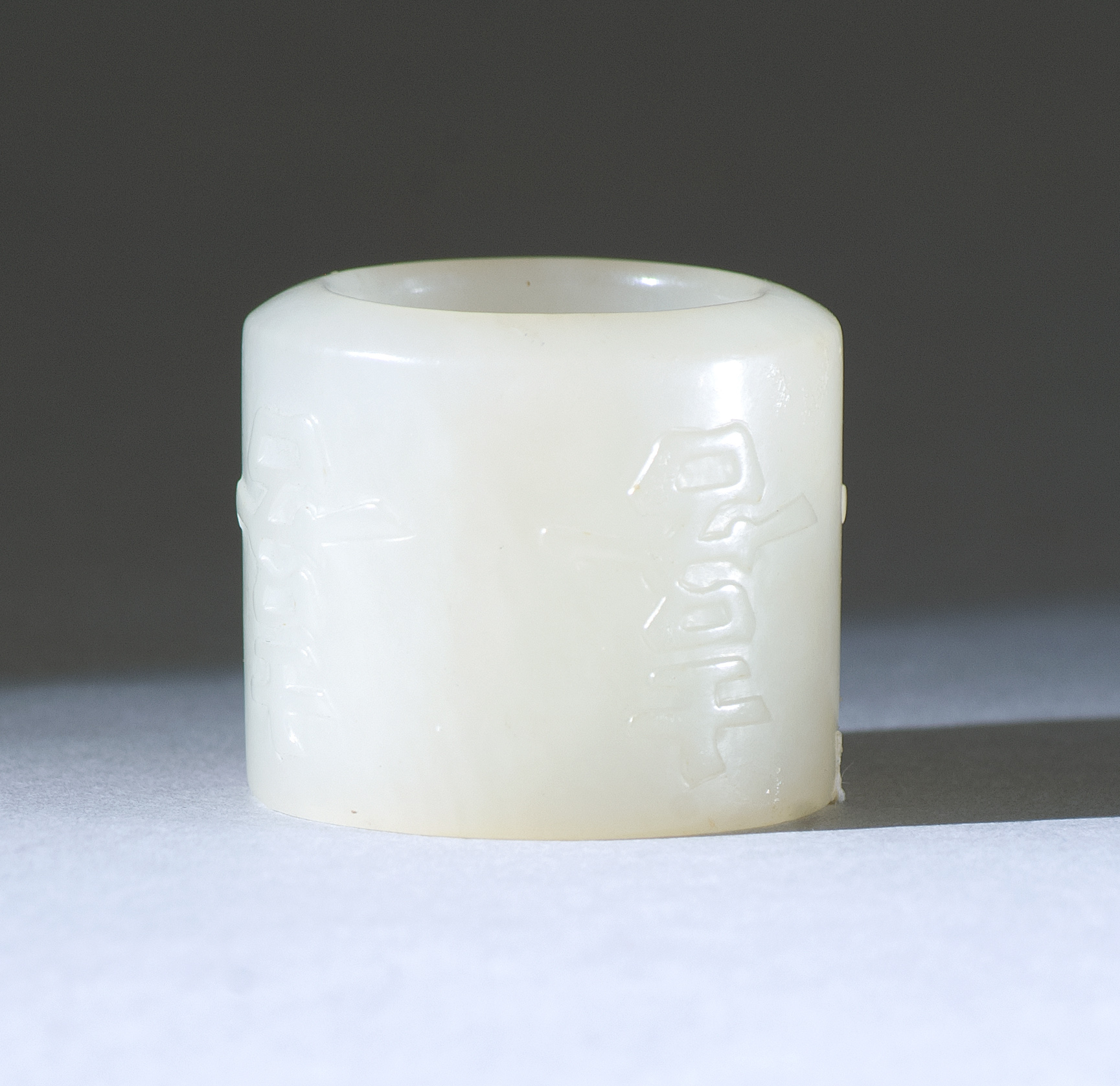 Appraisal: WHITE JADE THUMB RING th CenturyWith raised calligraphic design of