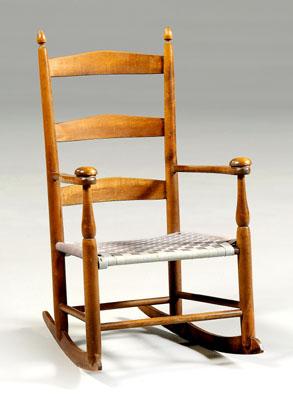 Appraisal: Shaker child s rocker ladder back below acorn finials woven