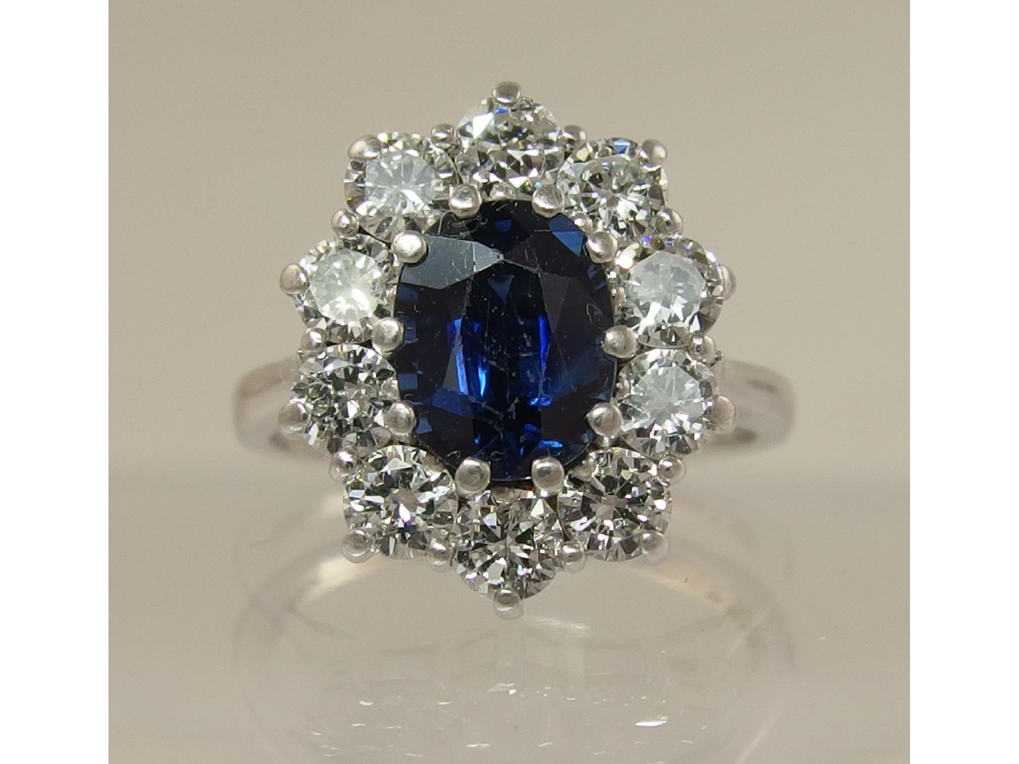 Appraisal: An ct white gold sapphire and diamond cluster ringthe central