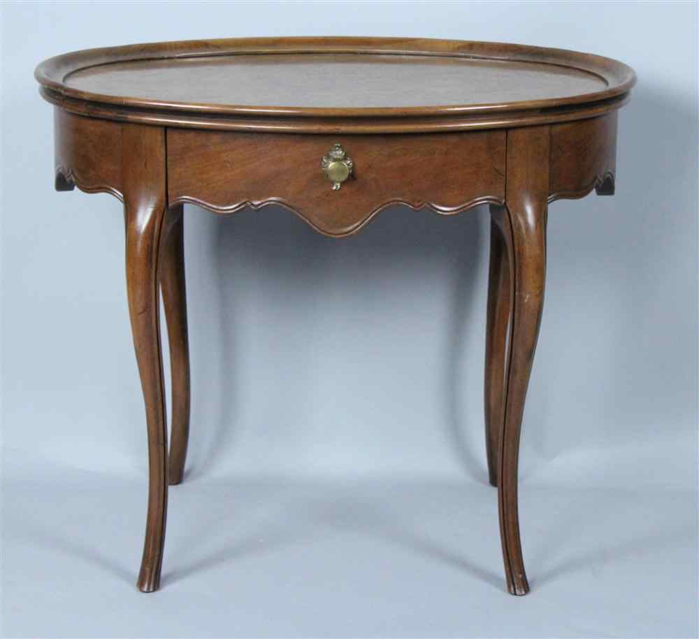 Appraisal: BAKER OVAL WALNUT FRENCH PROVINCIAL STYLE TEA TABLE having a