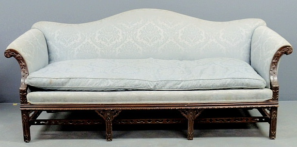 Appraisal: Chippendale style mahogany camelback sofa with floral carved arm supports