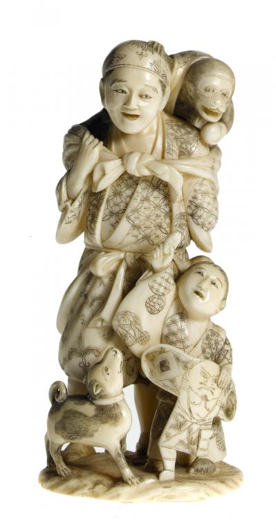 Appraisal: AN IVORY GROUP OF A TRAVELLING ENTERTAINER AND BOY the