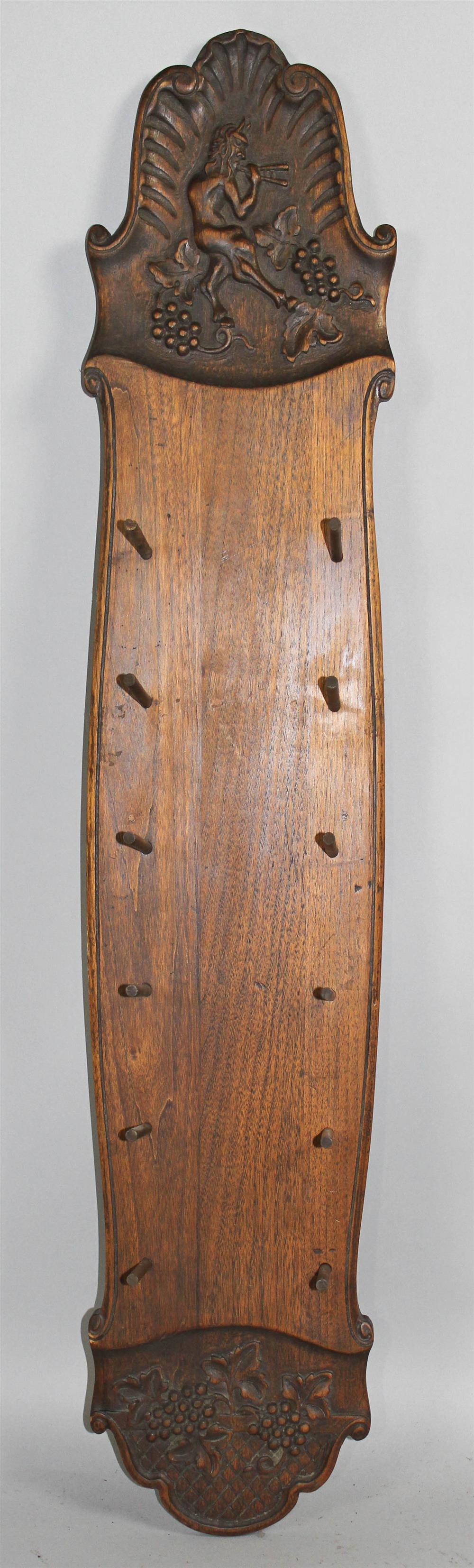 Appraisal: CARVED WALNUT HANGING RACK the shaped back board carved with