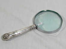 Appraisal: A magnifying glass with a silver handle the handle hallmarked