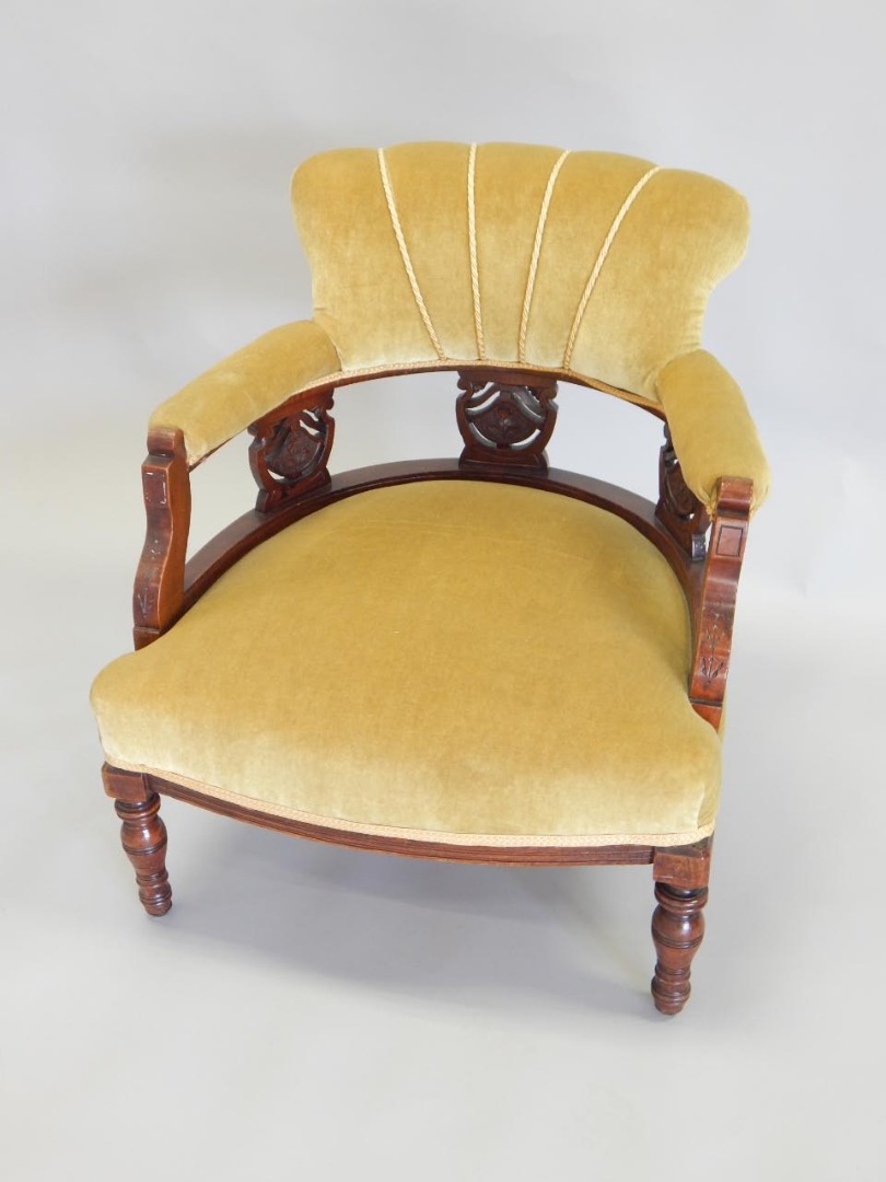 Appraisal: A late Victorian walnut tub shaped chair with a padded