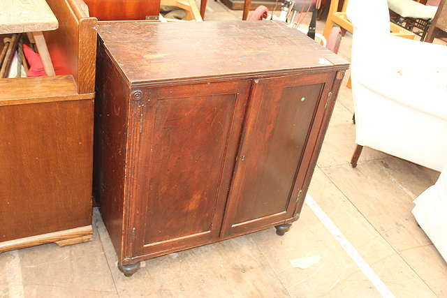 Appraisal: A GEORGIAN MAHOGANY CUPBOARD with two panelled doors standing on