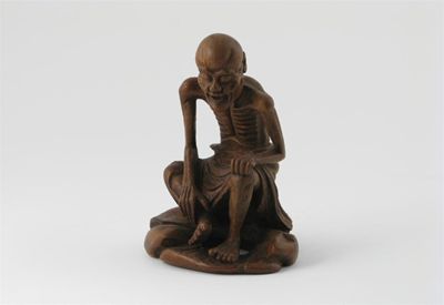 Appraisal: A Chinese bamboo carving of an ascetic seated on rocks