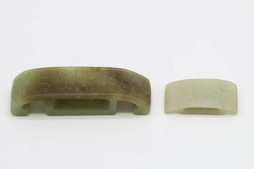 Appraisal: TWO JADE CARVED BELT HOOKS an archaistic rectangular jade sword