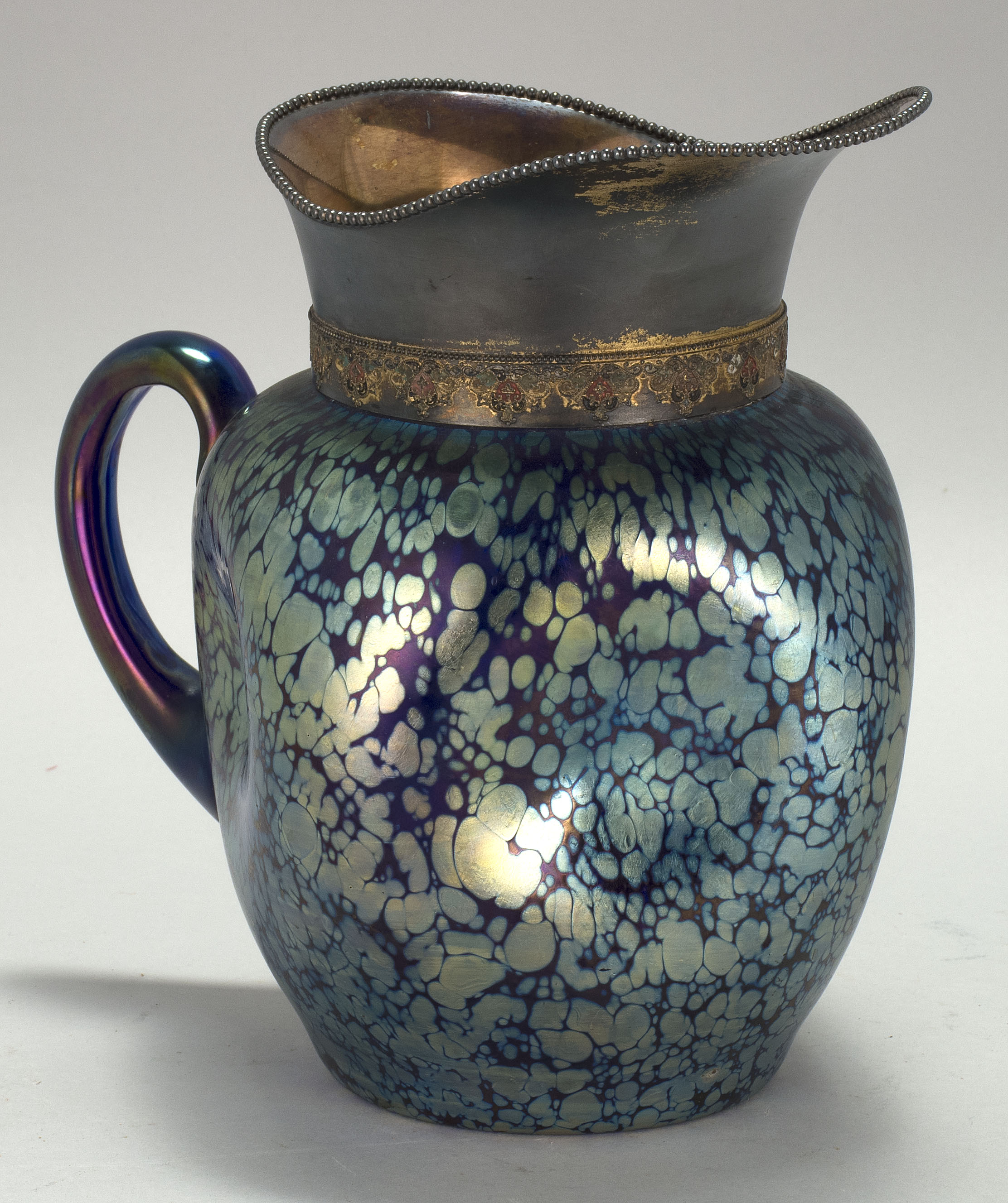 Appraisal: AUSTRIAN ART GLASS AND SILVER PLATED PITCHER Circa In iridescent