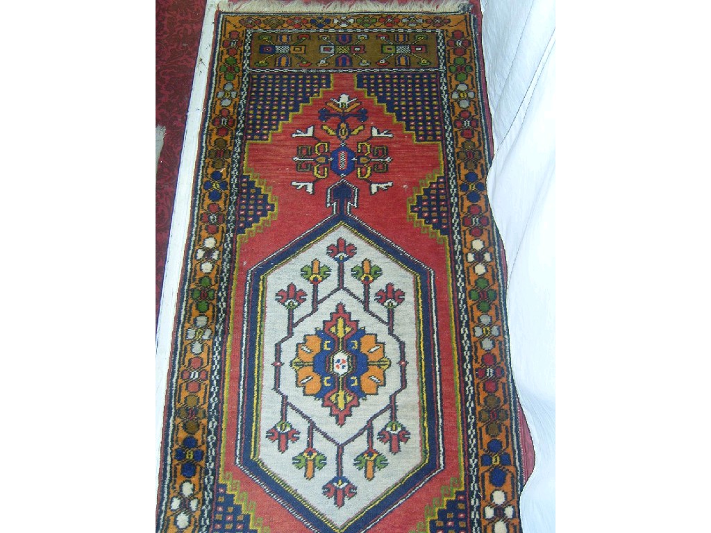 Appraisal: A Persian style runner with medallion centre upon a brick