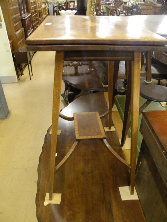 Appraisal: An Edwardian mahogany and marquetry card table with satinwood cross