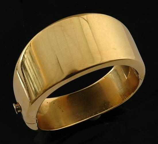 Appraisal: A gold bangle by Kria The wide hinged bangle of