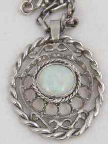 Appraisal: A white metal tests gold oval pendant with rope border