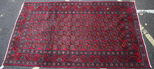 Appraisal: A BALUCHI RED GROUND RUG with geometric decoration to the