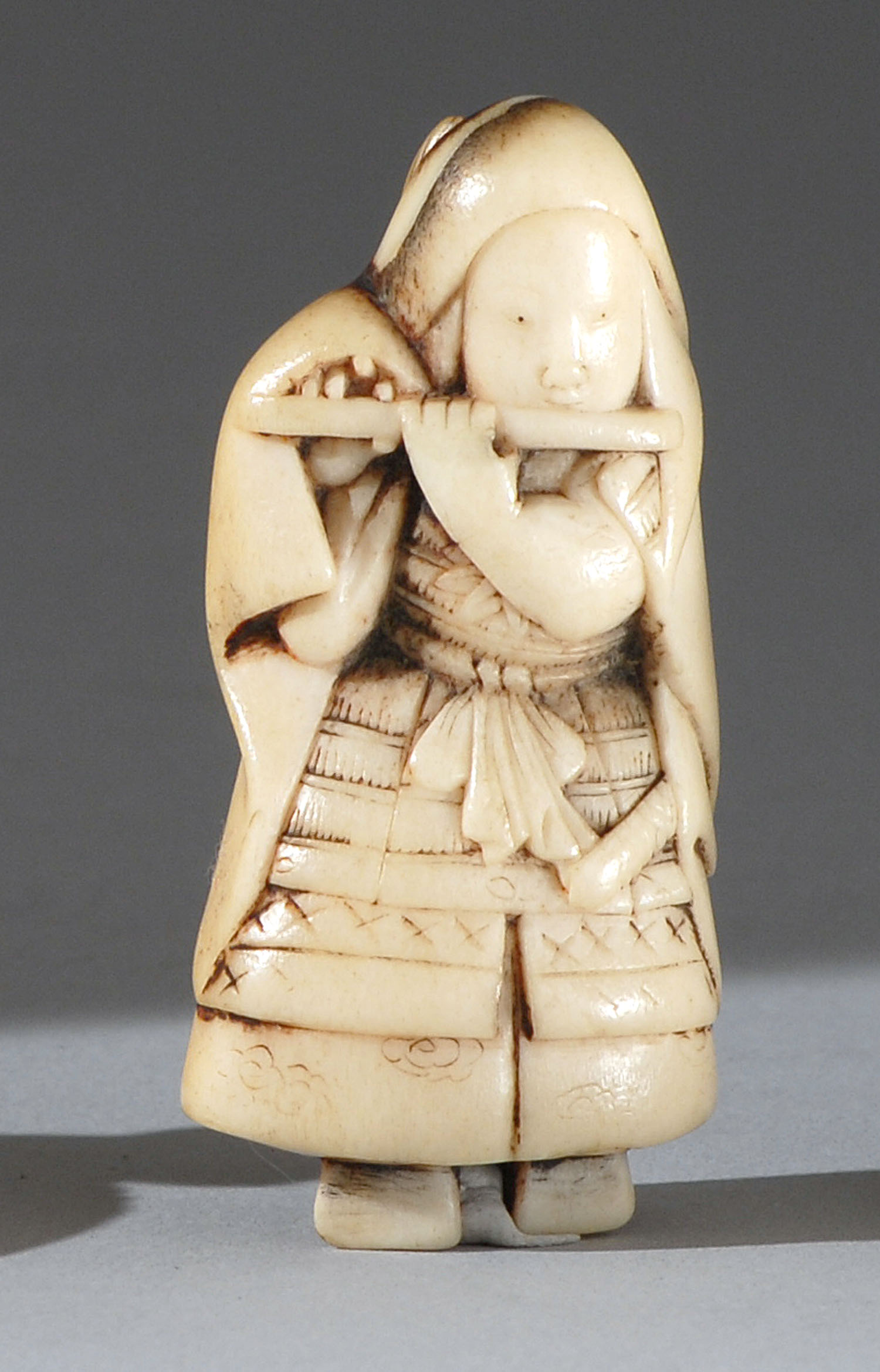 Appraisal: BONE NETSUKE th CenturyDepicting a warrior wearing armor and playing