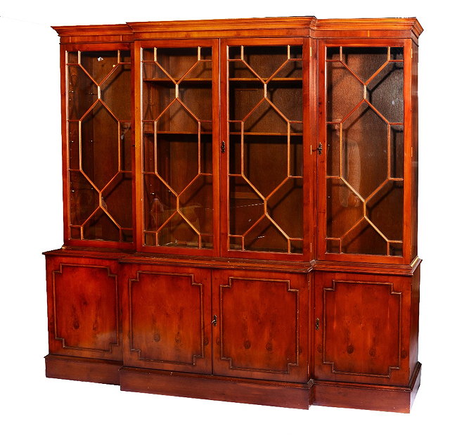 Appraisal: A REPRODUCTION YEW WOOD BREAK FRONT BOOKCASE with astragal glazed