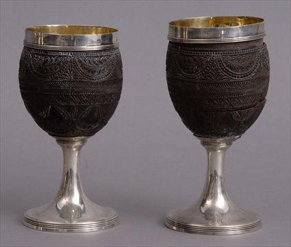 Appraisal: PAIR OF GEORGE III SILVER-MOUNTED ARMORIAL-CARVED COCONUT SHELL GOBLETS The