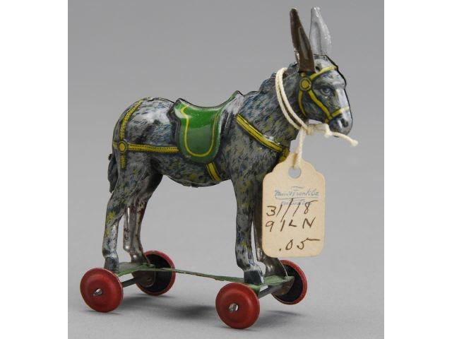 Appraisal: Penny Toy Donkey on Platform Germany ca Lithographed tin donkey