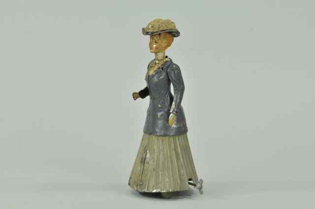 Appraisal: WOMAN WALKING TOY Germany hand painted tin tall figure appears