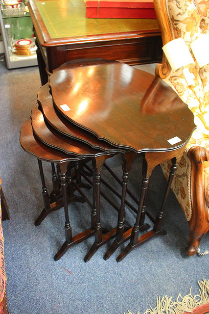 Appraisal: A NEST OF FOUR MAHOGANY OCCASIONAL TABLES with oval serpentine