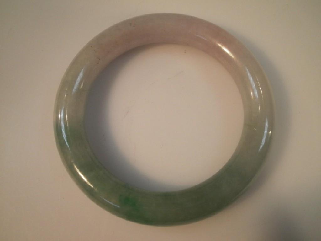 Appraisal: A Chinese green stone bangle