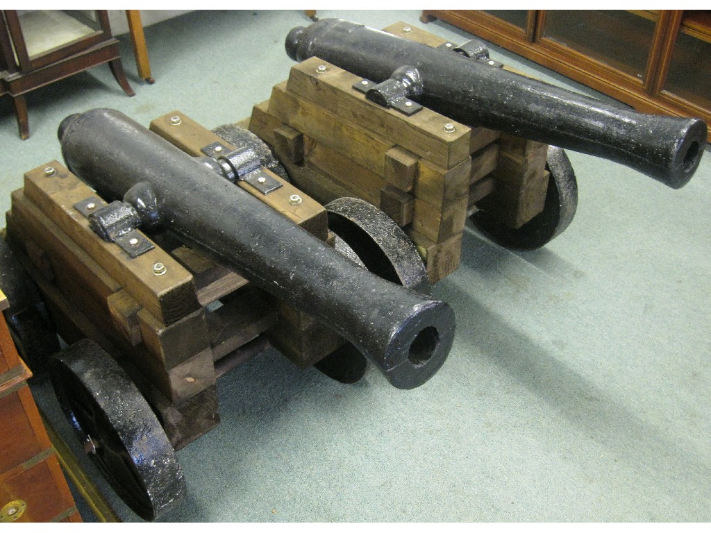 Appraisal: Pair of cast metal cannons on wheeled bases