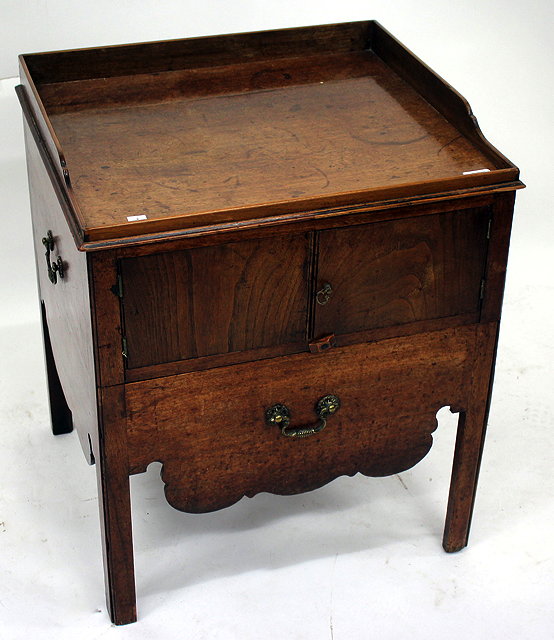 Appraisal: A COMMODE TABLE the raised galleried top over two cupboard