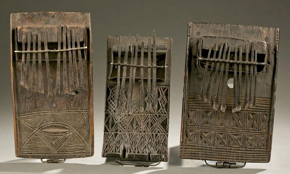 Appraisal: thumb pianos with carved linear motifs A group of three