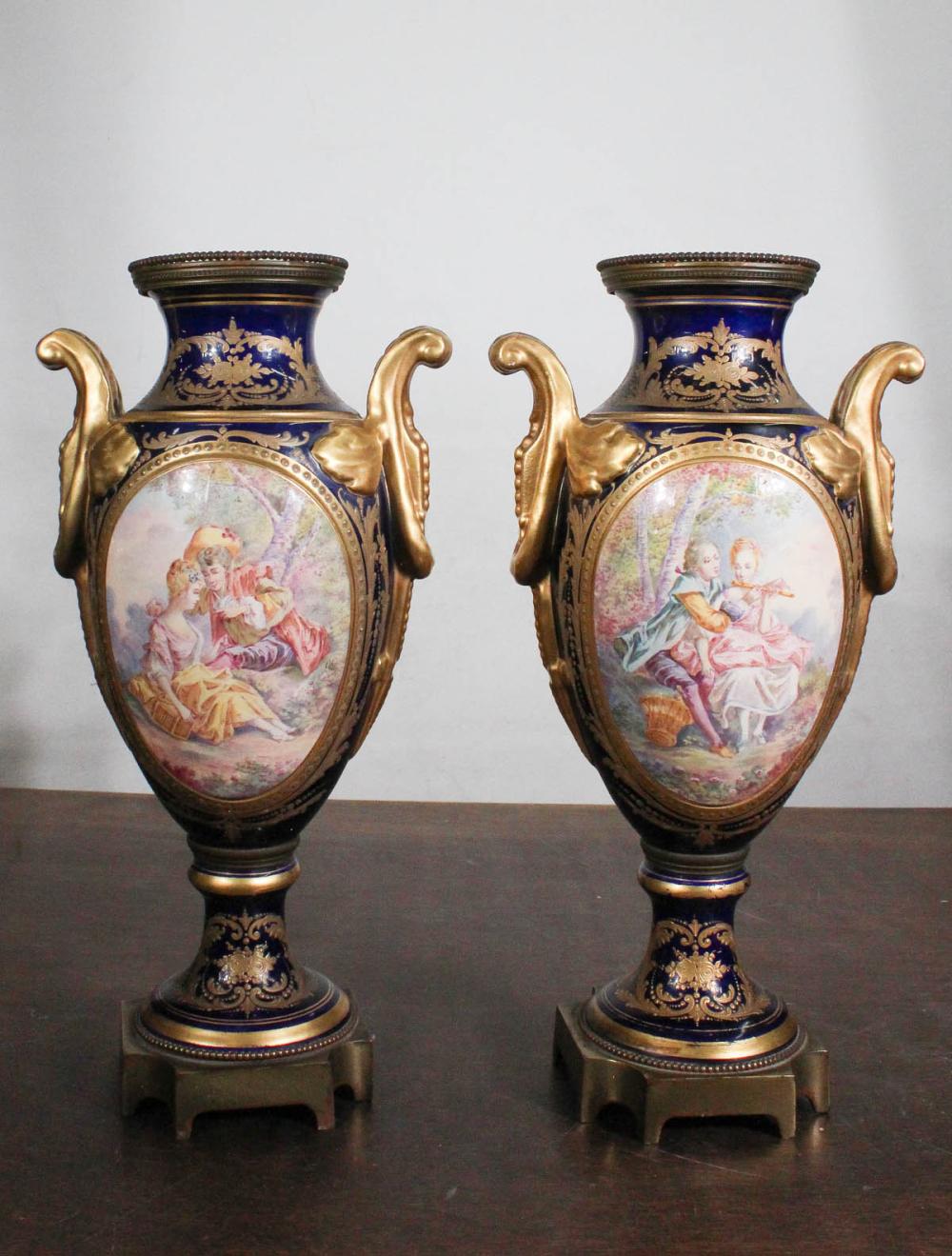 Appraisal: PAIR OF SEVRES STYLE PORCELAIN GILT METAL URNS featuring hand