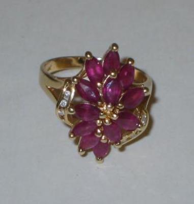 Appraisal: A RUBY CLUSTER RING claw set with marquise cut rubies