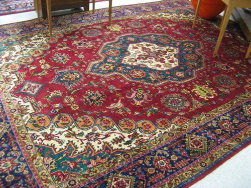 Appraisal: PERSIAN TABRIZ CARPET centering a green flower-filled geometric medallion on