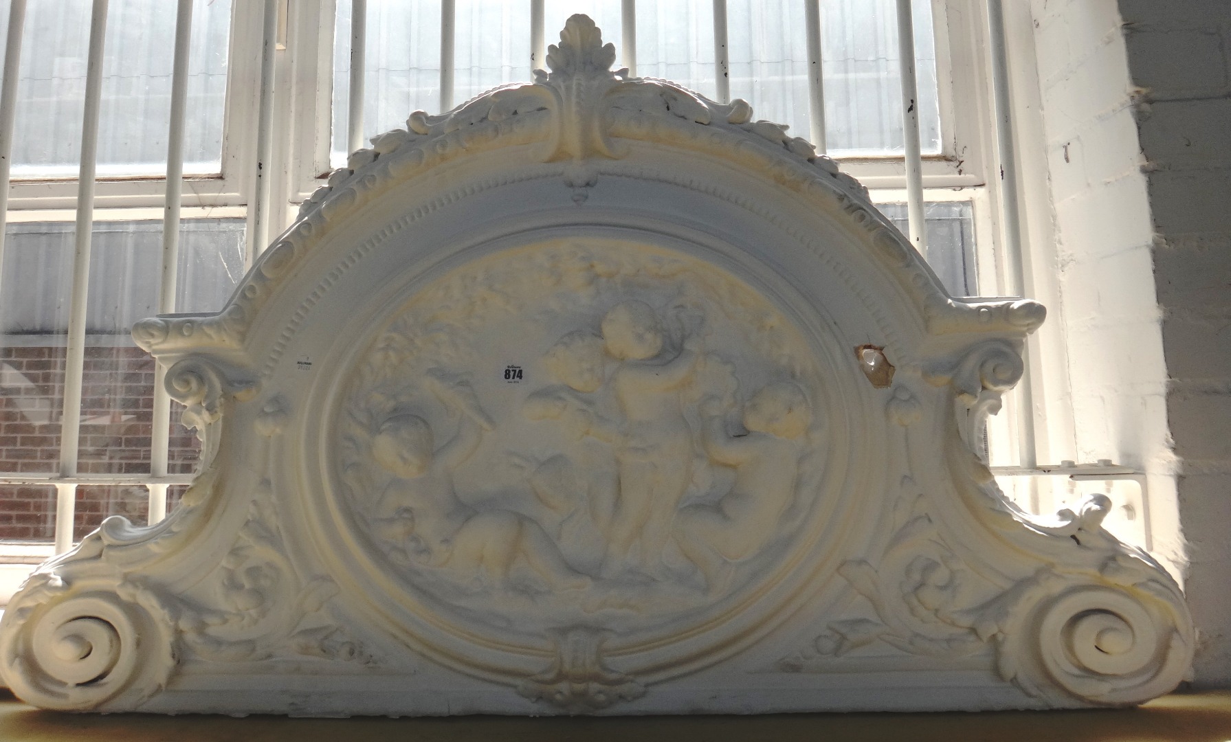 Appraisal: A relief moulded plaster surmount detailed with cherubic figures cm