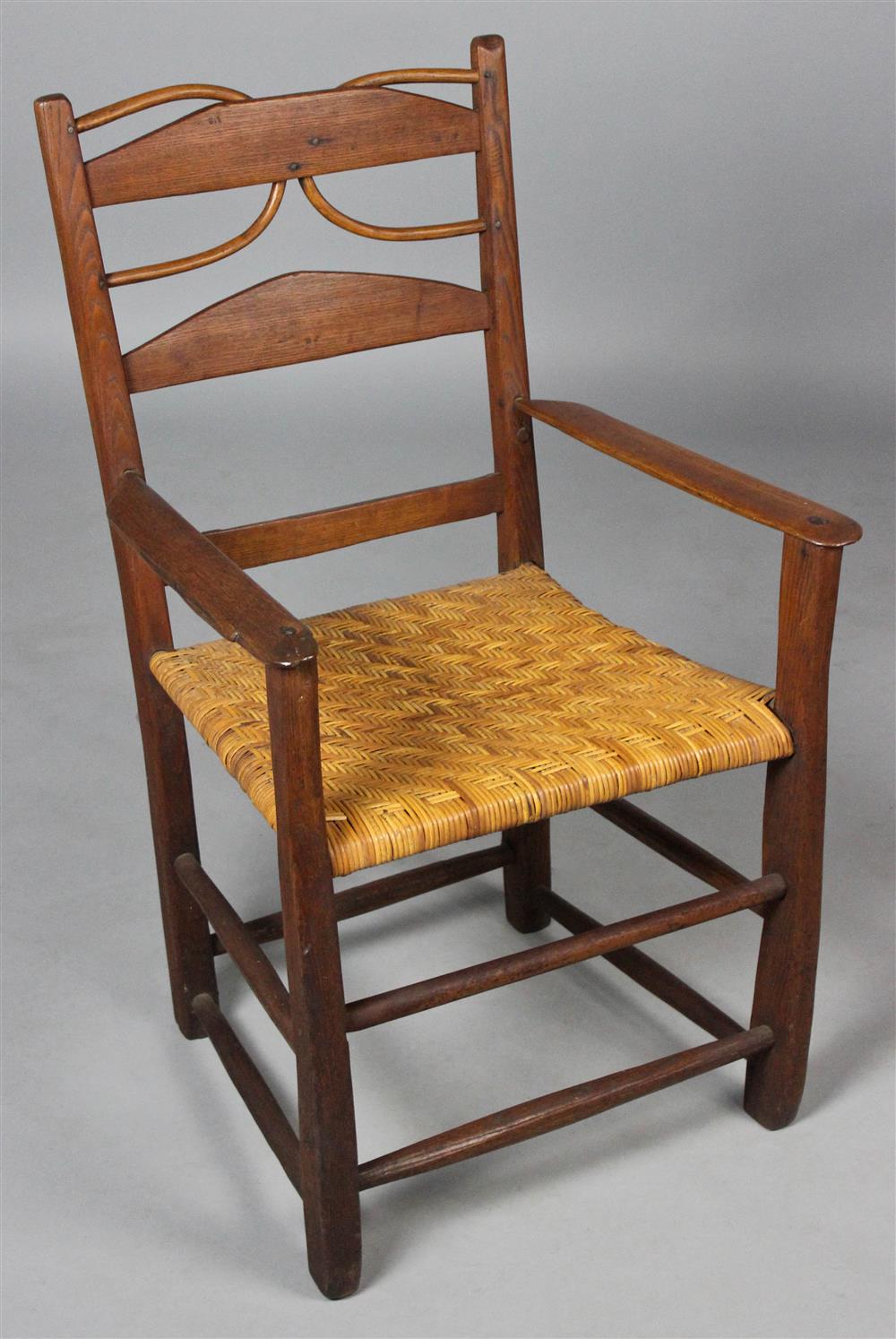 Appraisal: HARDWOOD ARM CHAIR WITH RUSH SEAT having a ladder back