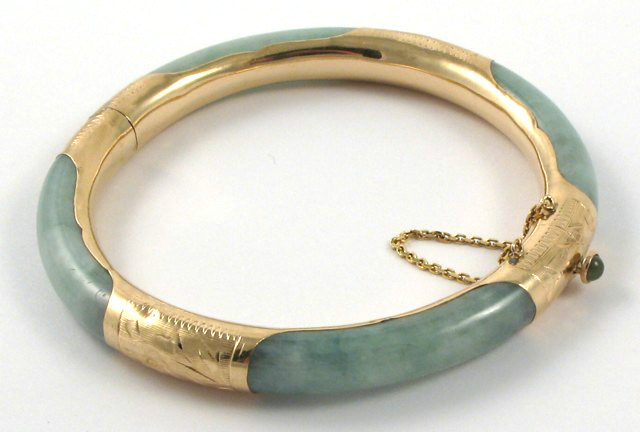 Appraisal: JADEITE AND FOURTEEN KARAT GOLD BANGLE The round hinged bangle