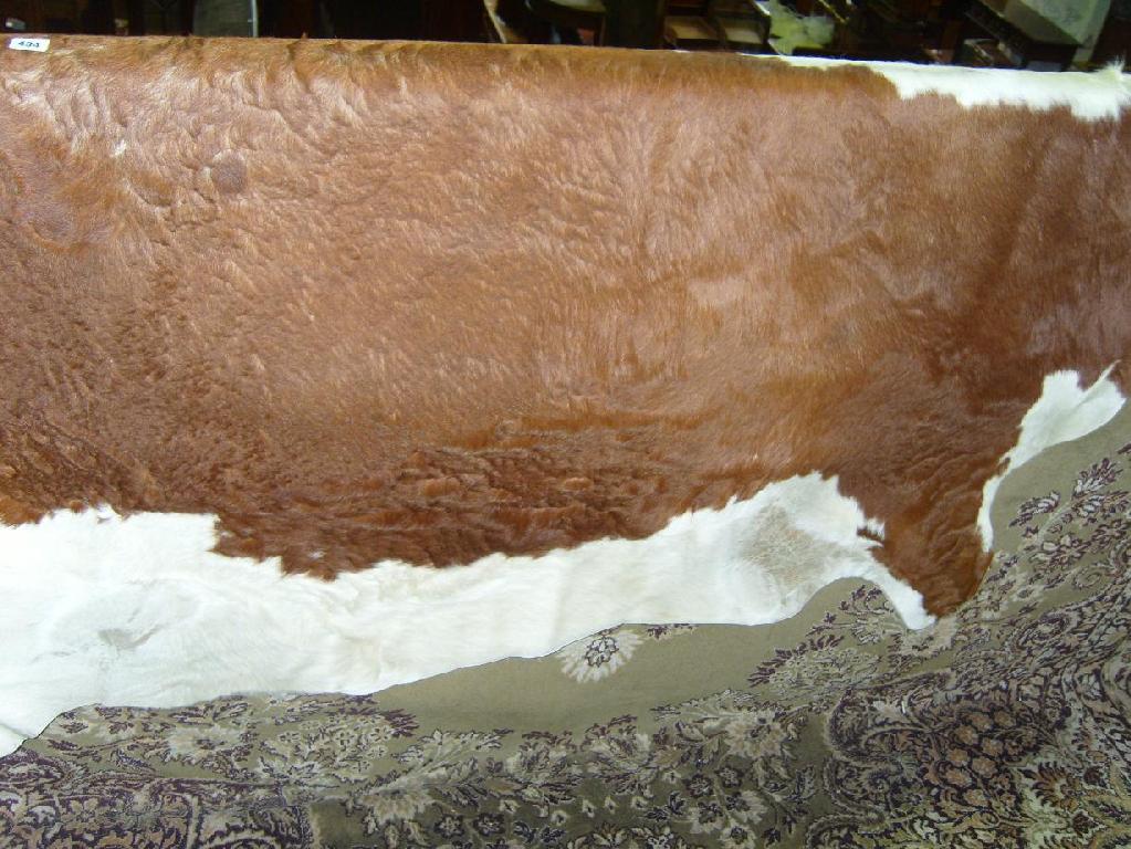 Appraisal: A cow hide with brown and white markings