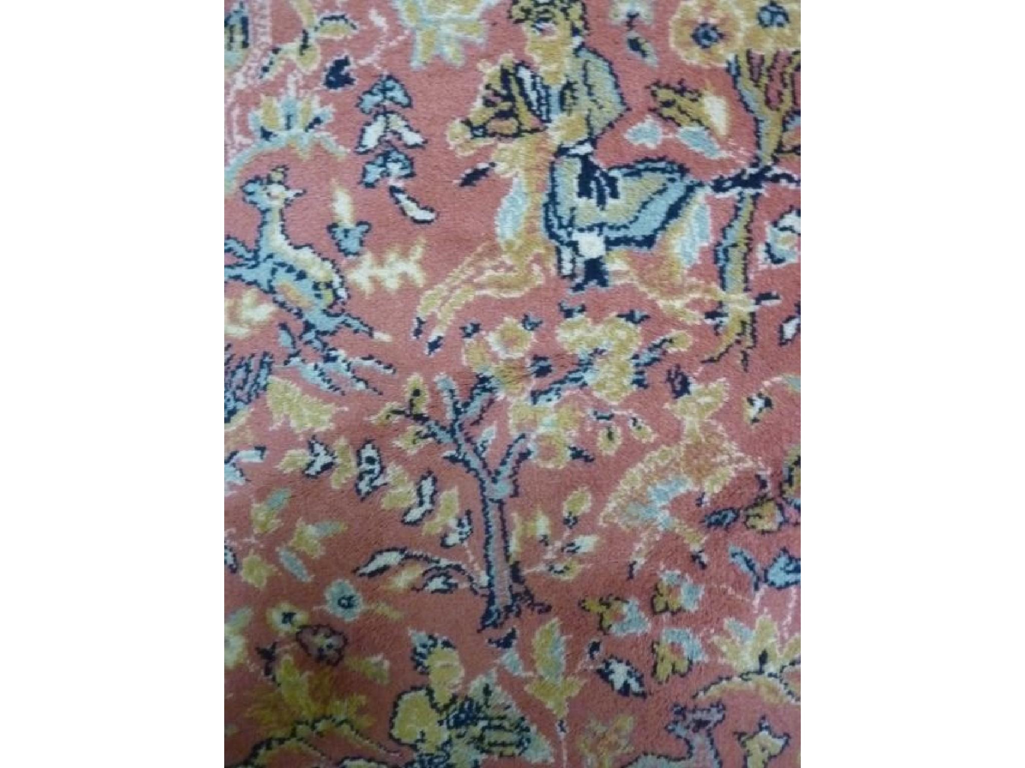 Appraisal: A Persian carpet with hunting scene detail upon a rust